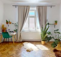 Living room in a 3-room apartment with a desk, plants, and a wooden decor floor.