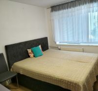Bedroom in a 2-room apartment with a comfortable bed and a large window.