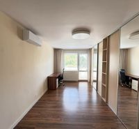 Interior of a 3-room apartment with a wooden decor floor and a built-in wardrobe.