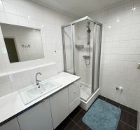 Bathroom in a 3-room apartment with a shower and white tiles.