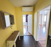 A yellow hallway with a table, mirror, and air conditioning in a 3-room apartment.