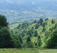 Hilly landscape around Hriňová with green gardens and extensive forest area.