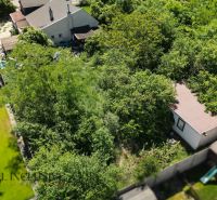Plots - housing in Dunajská Lužná with garden greenery and a small building.