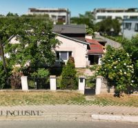 A family house in the area of Dunajská Lužná, surrounded by greenery and adjacent residential plots.