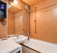 A bathroom with a shower, a bathtub, and storage space in a 4-room apartment.