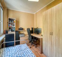 A room with a wooden floor decor, a bed, and a desk in a 4-room apartment.