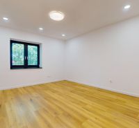 A room in a family house with white walls and a wooden decor floor.