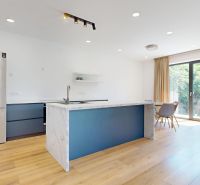A kitchen in a family house with an island and a wooden decor floor.