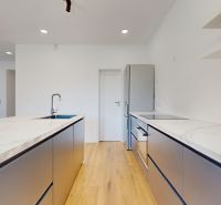A kitchen in a family house with modern appliances and a wooden decor floor.