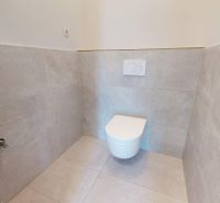 A bathroom in a family house with ceramic tiles in a neutral color.