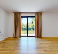 A room in a family house with a floor featuring a wooden decor and curtains.