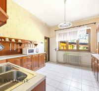 A kitchen with wooden decor and white tiles in a family house.