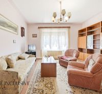 Living room in a family house with a sofa, armchairs, and wooden furniture.