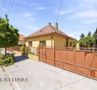 A family house in Dunajská Streda with a fence and trees in front of the entrance.