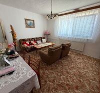 Living room in a family house with floral decorations and plenty of textiles.