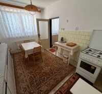 A kitchen in a family house with a dining table, a gas stove, and vintage decoration.
