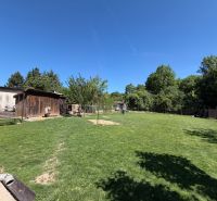 The garden at the family house on Tichá Street in Hajná Nová Ves with a lawn and a wooden shelter.