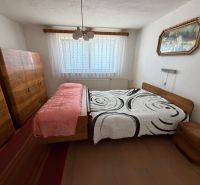 Bedroom in a family house with wooden cabinets and a bed on a wooden decor.