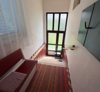 Staircase in a family house with a bench, carpet, and glass doors.