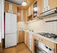 A kitchen unit in a 3-room apartment with a stove and a floor with a wooden decor.