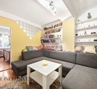 Living room with a sofa, shelves, and lots of cushions in a 3-room apartment.