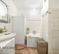 Bathroom with a bathtub, sink, mirror, and storage cabinets in a 3-room apartment.