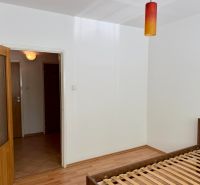 Bedroom in a 4-room apartment with a bed and a wooden decor floor.