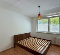 Bedroom in a 4-room apartment with a bed and a wooden decor floor.