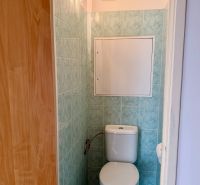 A toilet with blue tiles in a 4-room apartment.