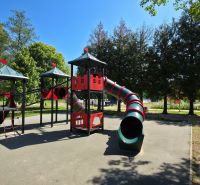 A children's playground with climbing frames and slides surrounded by trees at the Cottage in Šaštín-Stráže.