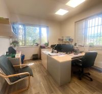 An office with a desk, chairs, and a wooden decor floor in commercial premises.