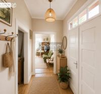 A hallway in a family house with a wooden decor floor and plants, bright atmosphere.