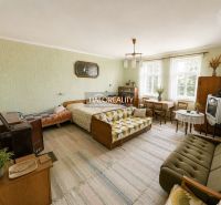 Living room with retro furniture in a family house, includes a sofa and a dining table.