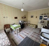 Interior of a family house with old furniture, carpets, and a wood-burning stove.