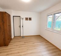 A cottage with a wooden wardrobe, a standing lamp, and a floor with a wooden decor.
