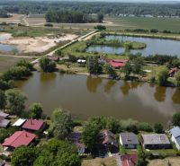 Cottages in Kopčany by the lake and surrounding nature, also visible are other bodies of water.