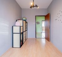 A room in a 3-room apartment with a wooden decor floor and wall decoration.