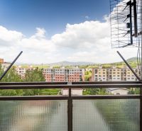 View from a 3-room apartment on 9th May Street in Brezno with apartment buildings and nature.