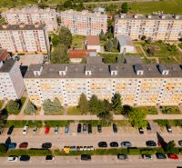 A top-down view of a row of apartment buildings on 9th May Street in Brezno with a parking lot.