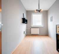 A room with a wooden floor decor, a window, and wall shelves in a 3-room apartment.