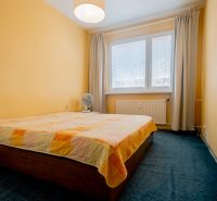 Bedroom in a 3-room apartment, with a double bed and yellow walls, blue carpet.
