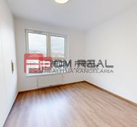 A bright room with wood-patterned flooring and white walls in a 3-room apartment.