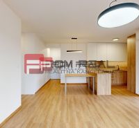 A kitchen with white cabinets and a wood-patterned floor in a 3-room apartment.