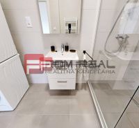 Bathroom in a 3-room apartment with a sink, shower, and washer with dryer.
