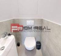 A toilet with a sink and modern tiles in a 3-room apartment.
