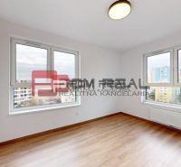 Spacious room with wood-patterned flooring, large windows, and a built-in wardrobe.
