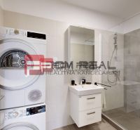 Bathroom of a 3-room apartment with a washing machine, dryer, and shower.