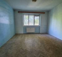 An empty room with a wooden floor and blue walls in a 3-room apartment.