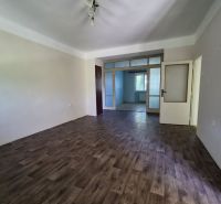 A room in a 3-room apartment with a floor featuring a wooden decor and white walls.