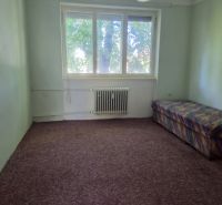 A room with a large window, radiator, carpeted floor, and a sofa in a 3-room apartment.